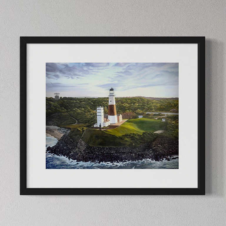 Framed artwork of a lighthouse on a cliff with ocean and sky.
