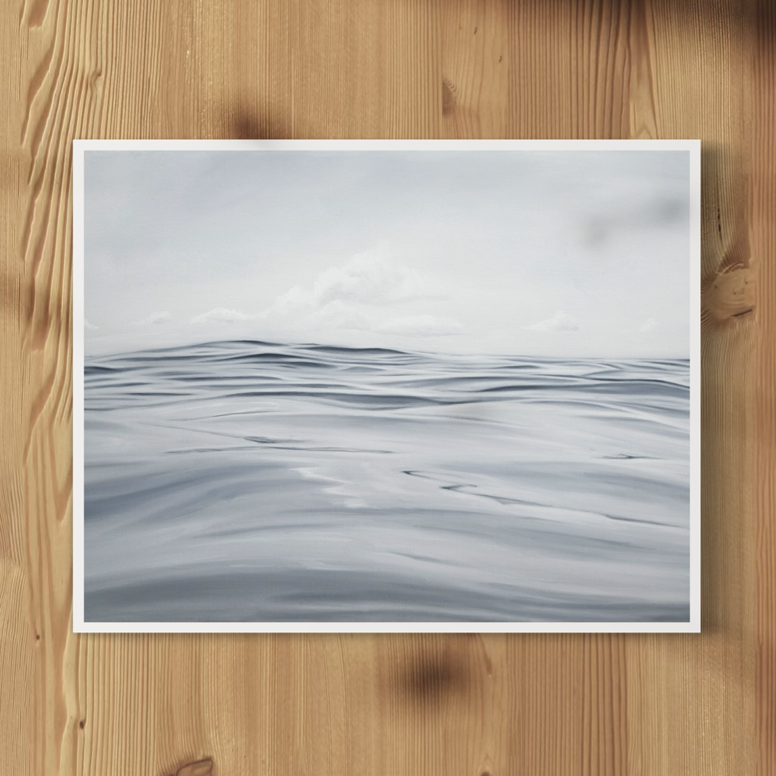 A framed print depicting a serene open sea scene with gentle waves and a calm horizon.
