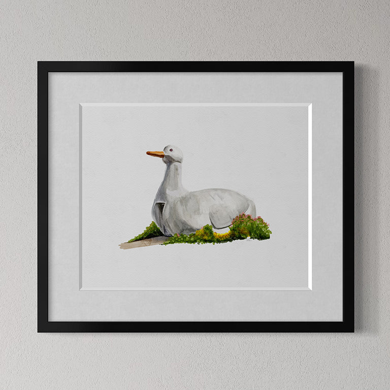 Framed artwork of of The Big Duck landmark in Flanders, Long Island, NY on grass against a gray wall