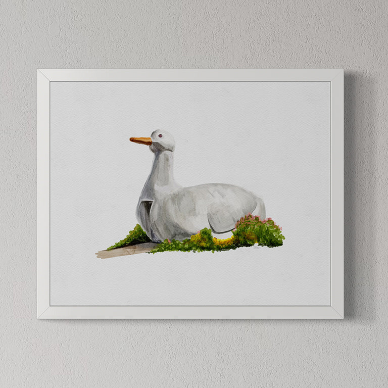 Framed artwork of The Big Duck landmark in Flanders, Long Island, NY on grass against a light gray wall.
