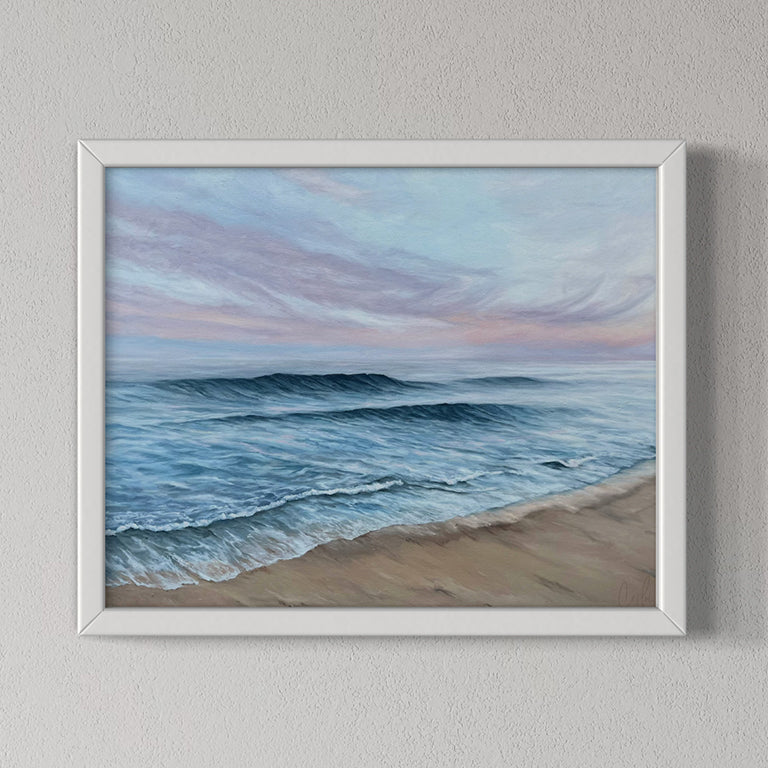 Framed painting of a beach scene with waves and sky.