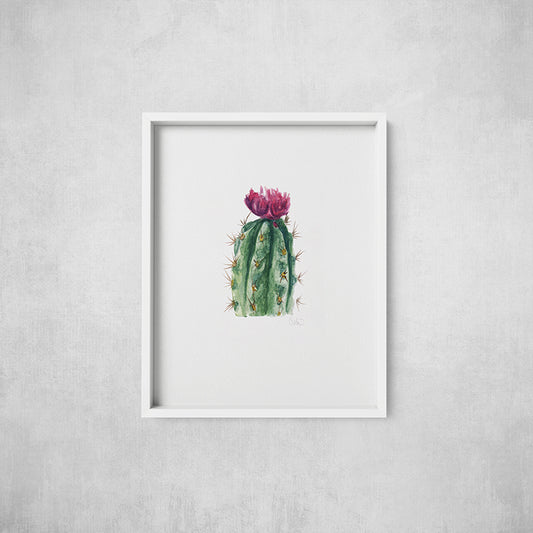 Framed artwork of a cactus with pink flower on a gray wall