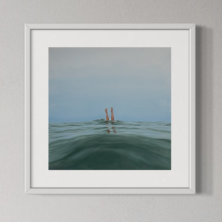 Framed artwork of a person standing in water with a gradient sky.