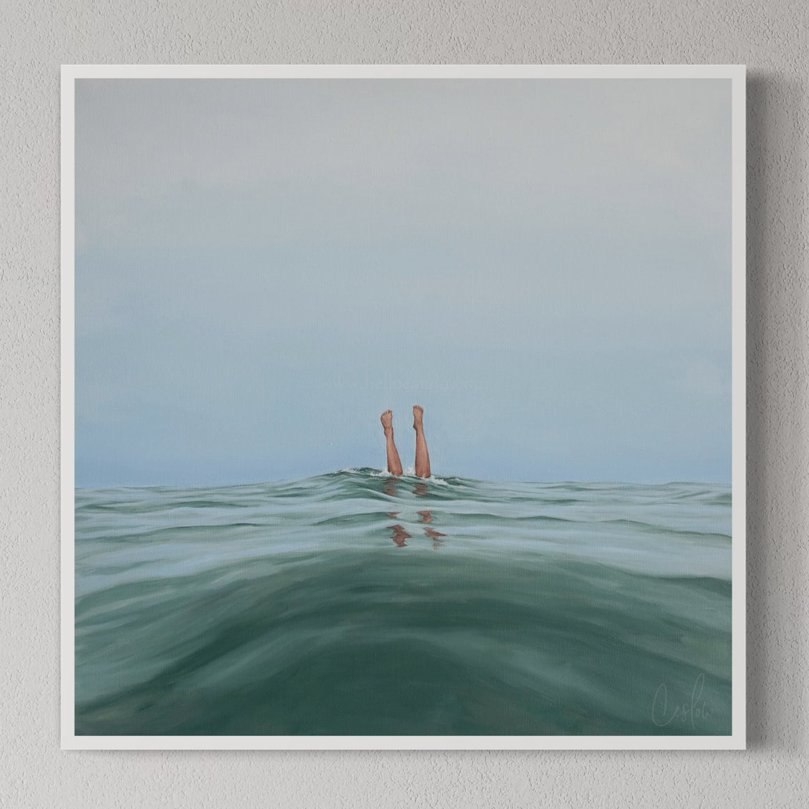 A framed art print titled 'Double Dipped, I', depicting two legs emerging from water, displayed on a wall shelf with decorative objects.