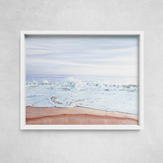 A framed print depicting a serene beach scene with a pastel-colored sunset and gentle waves.