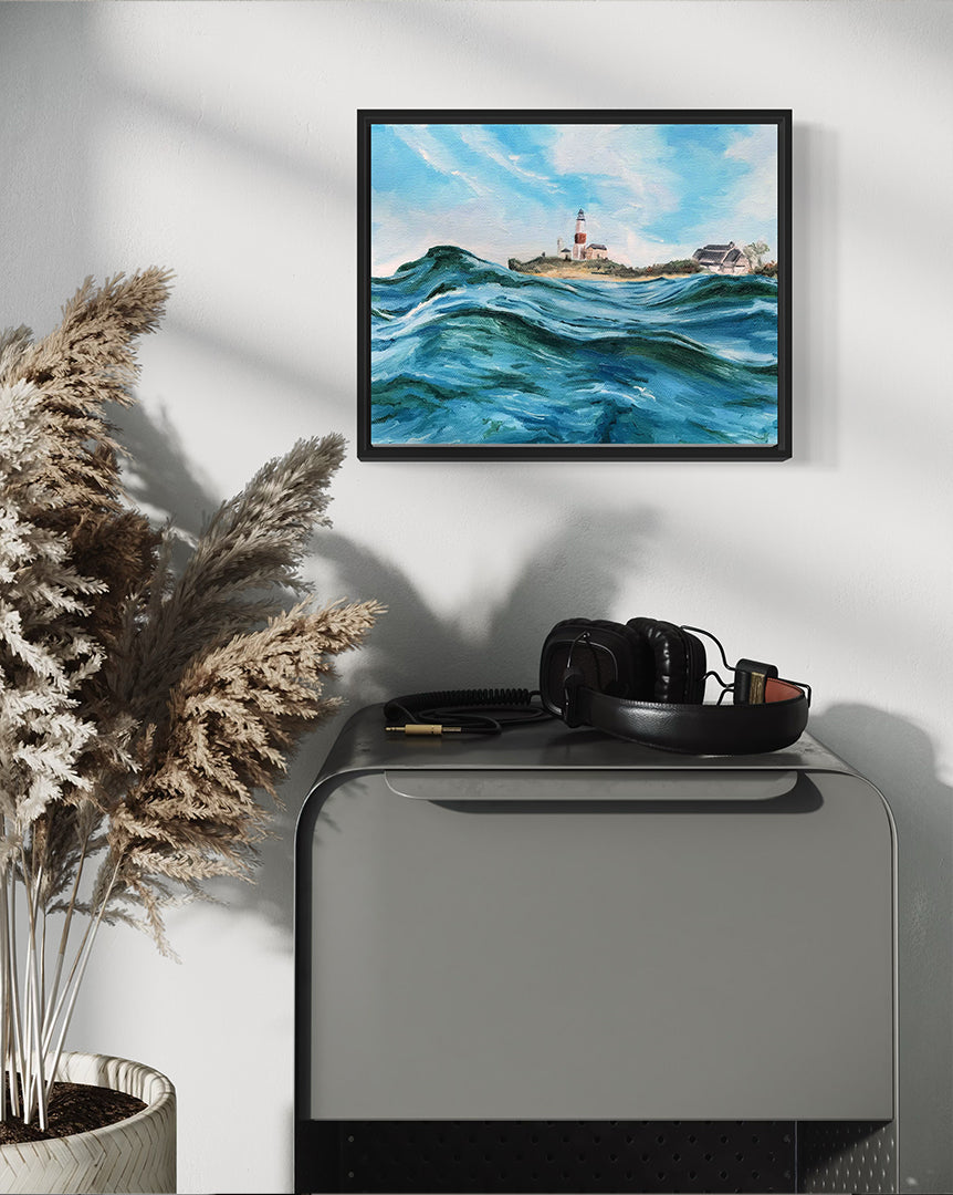 Framed artwork of a lighthouse scene on a wall above a console table with decorative items.