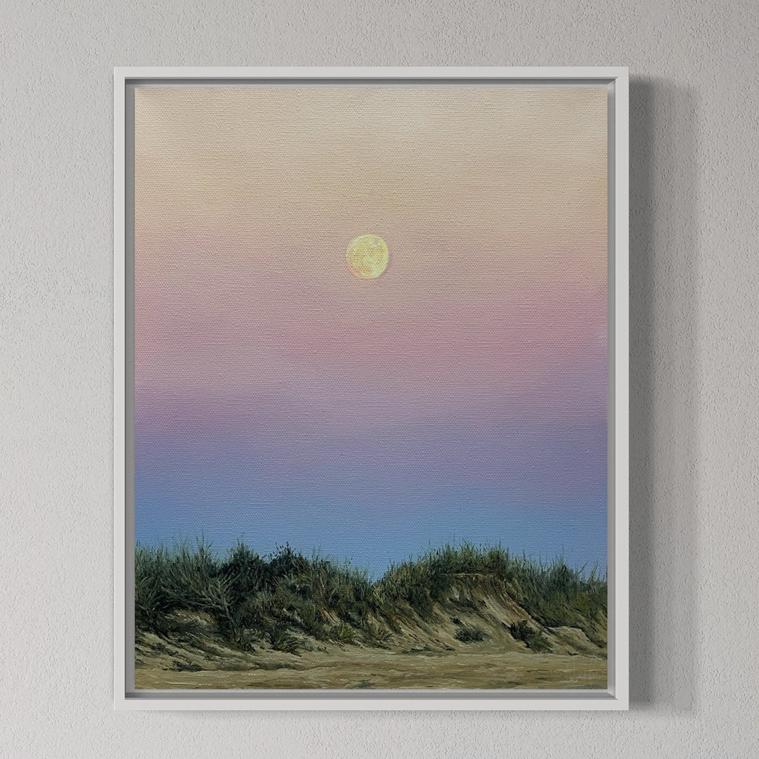 Framed artwork of a sunset over grassy dunes with a full moon.