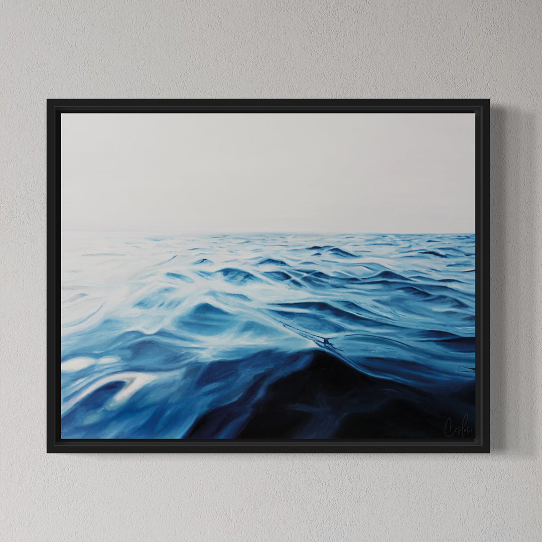 Framed artwork of wavy blue water on a gray wall