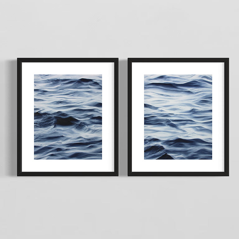 Two framed artworks of wavy blue patterns on a gray background