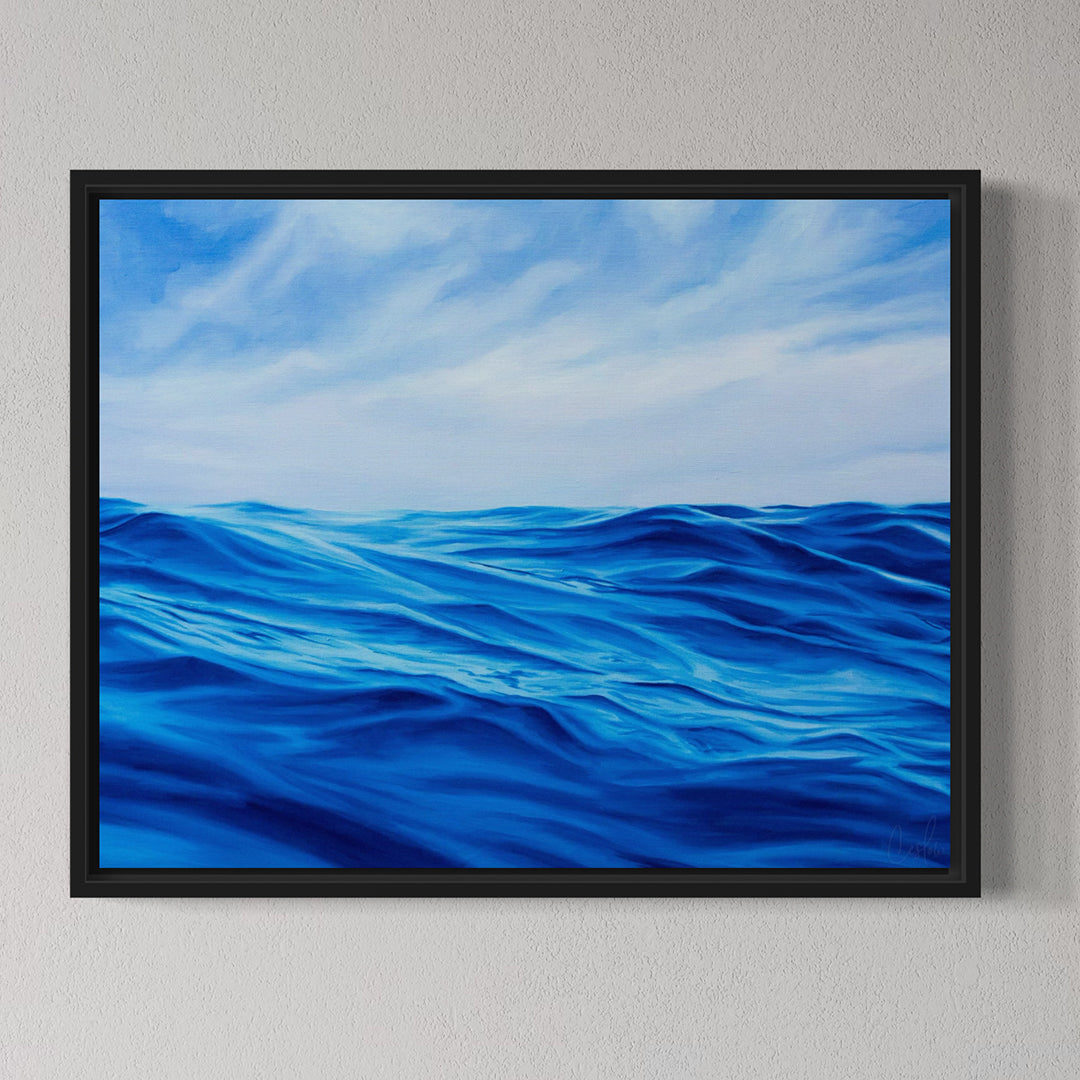 Framed artwork of blue ocean waves and sky on a gray wall