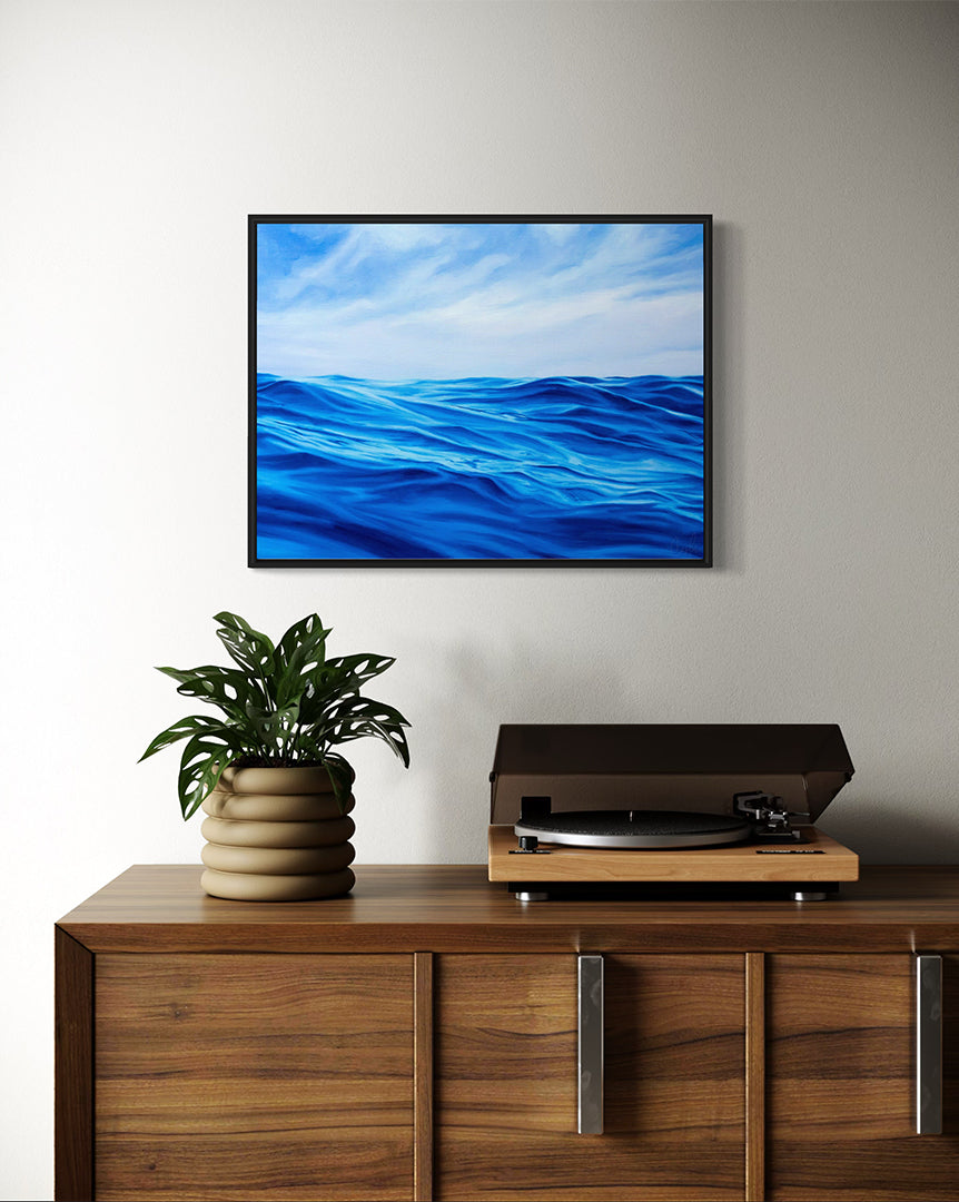 Wall-mounted TV displaying a blue ocean scene above a wooden cabinet with a plant and record player.