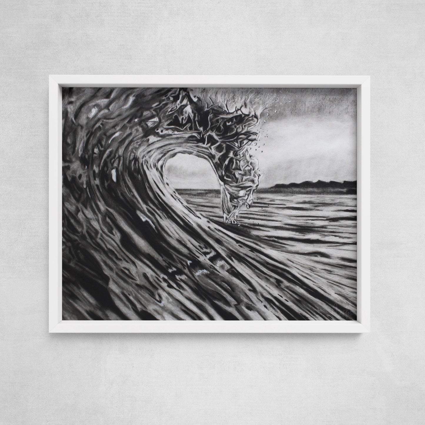 A framed black and white charcoal drawing of a breaking wave, displayed on a wall.