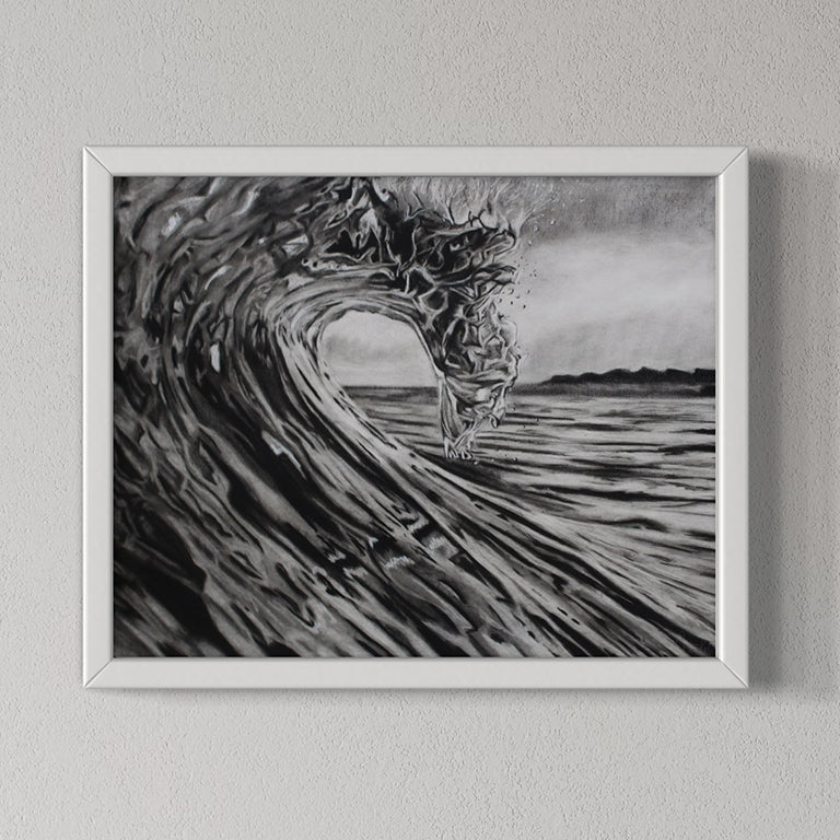 Framed black and white artwork of a wave on a gray wall