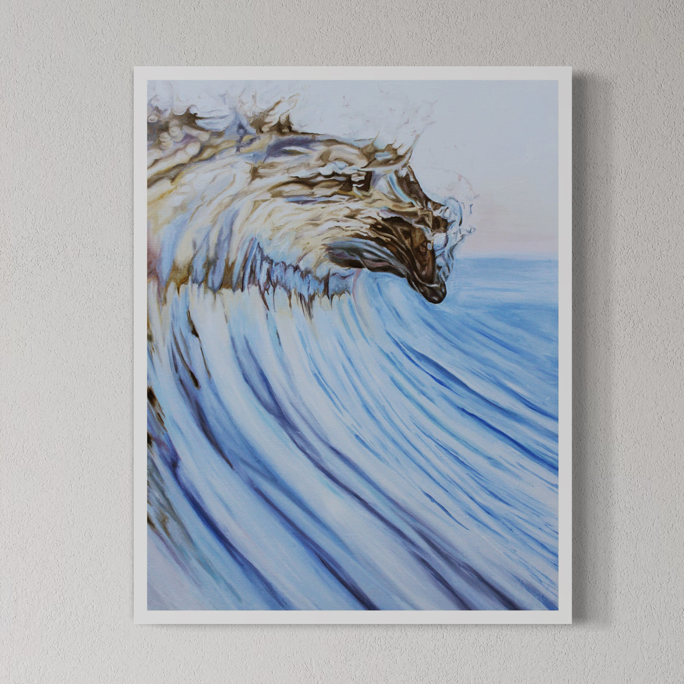 A framed fine art print of a blue wave with golden sunlight, displayed on a white wall.