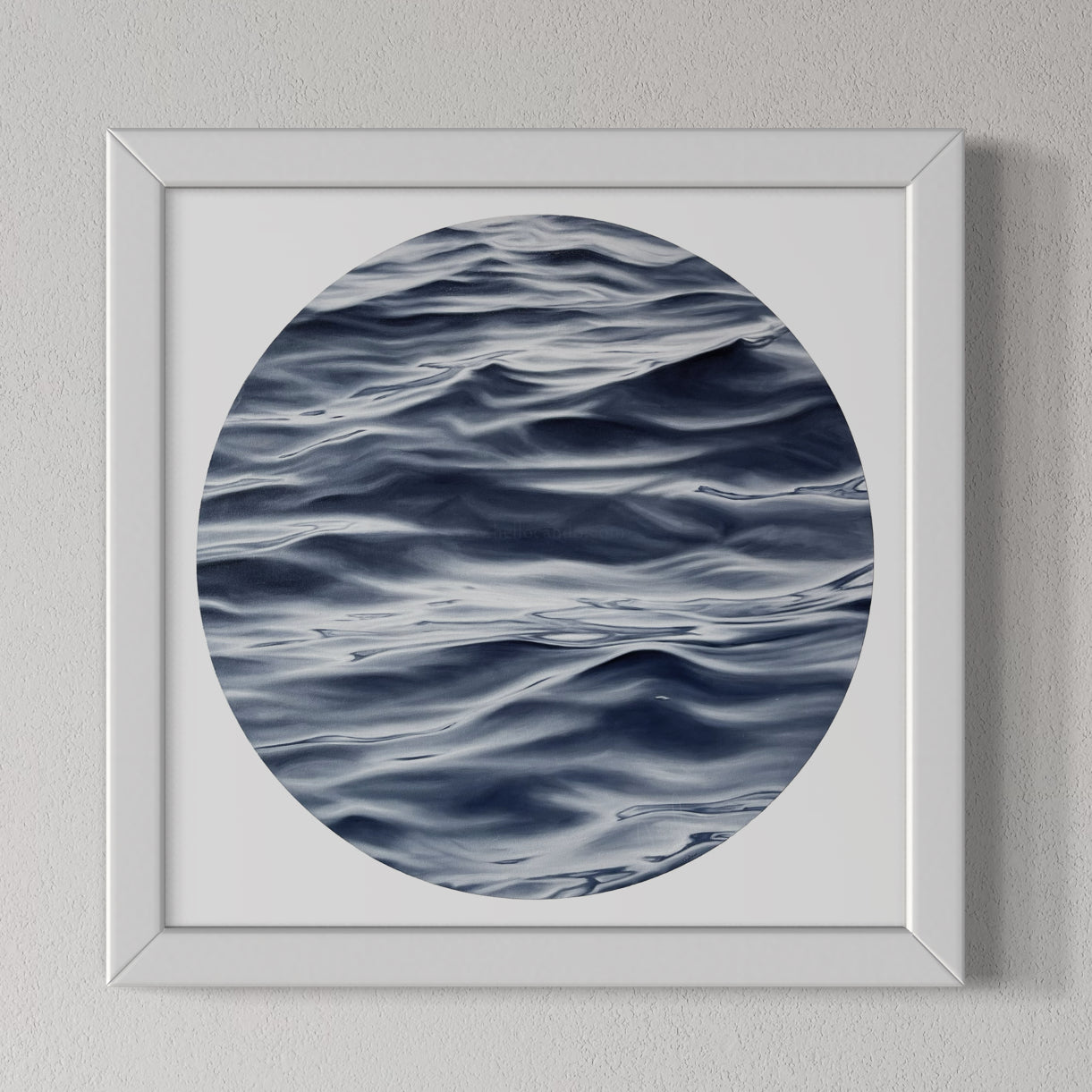 A framed fine art print of the ocean with a predominantly blue and white color palette, displayed on a wall.