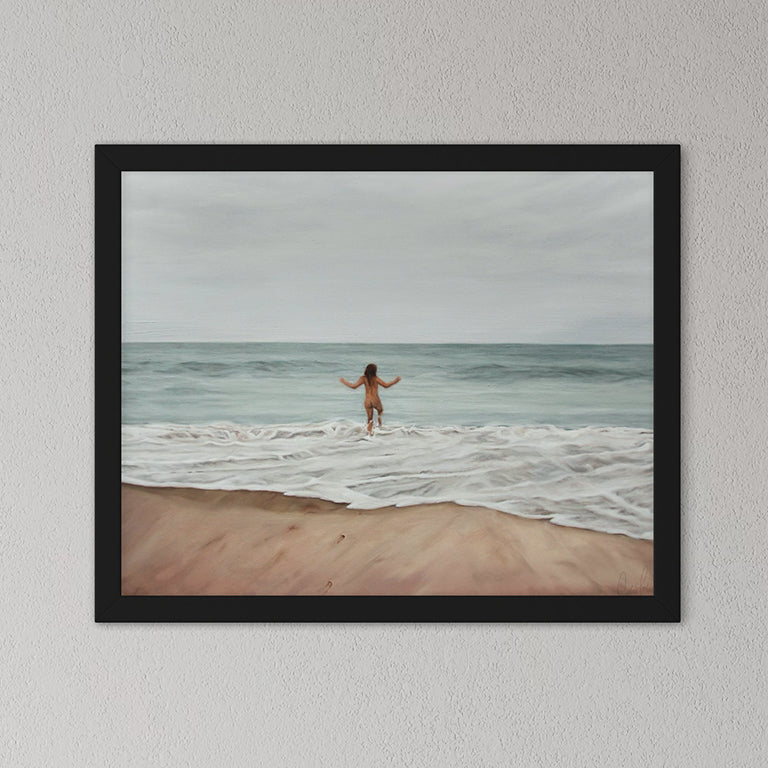 Framed artwork of a person standing on a beach with ocean waves.
