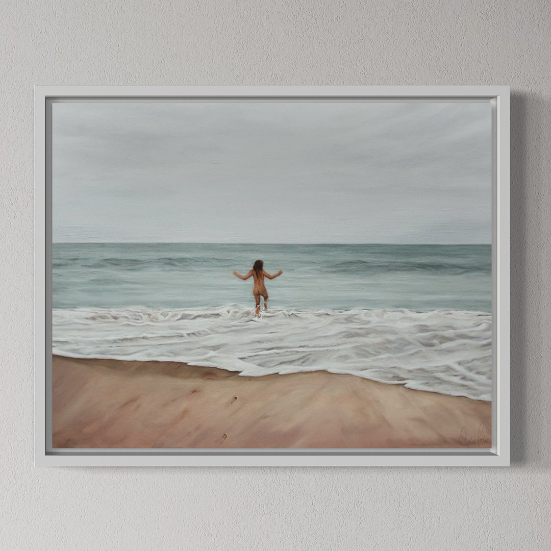Framed artwork of a person walking on a beach with ocean waves.