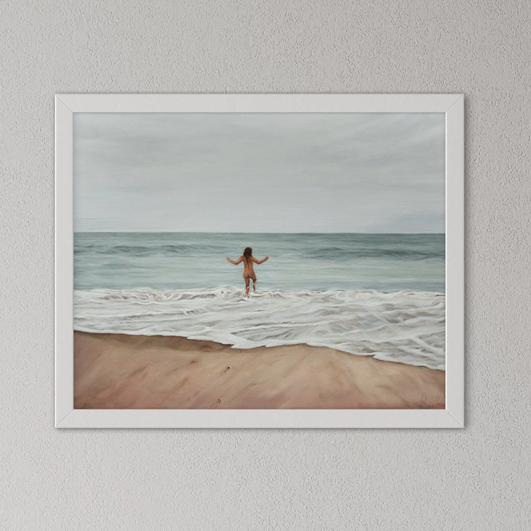 Framed artwork of a person standing on a beach with ocean waves.