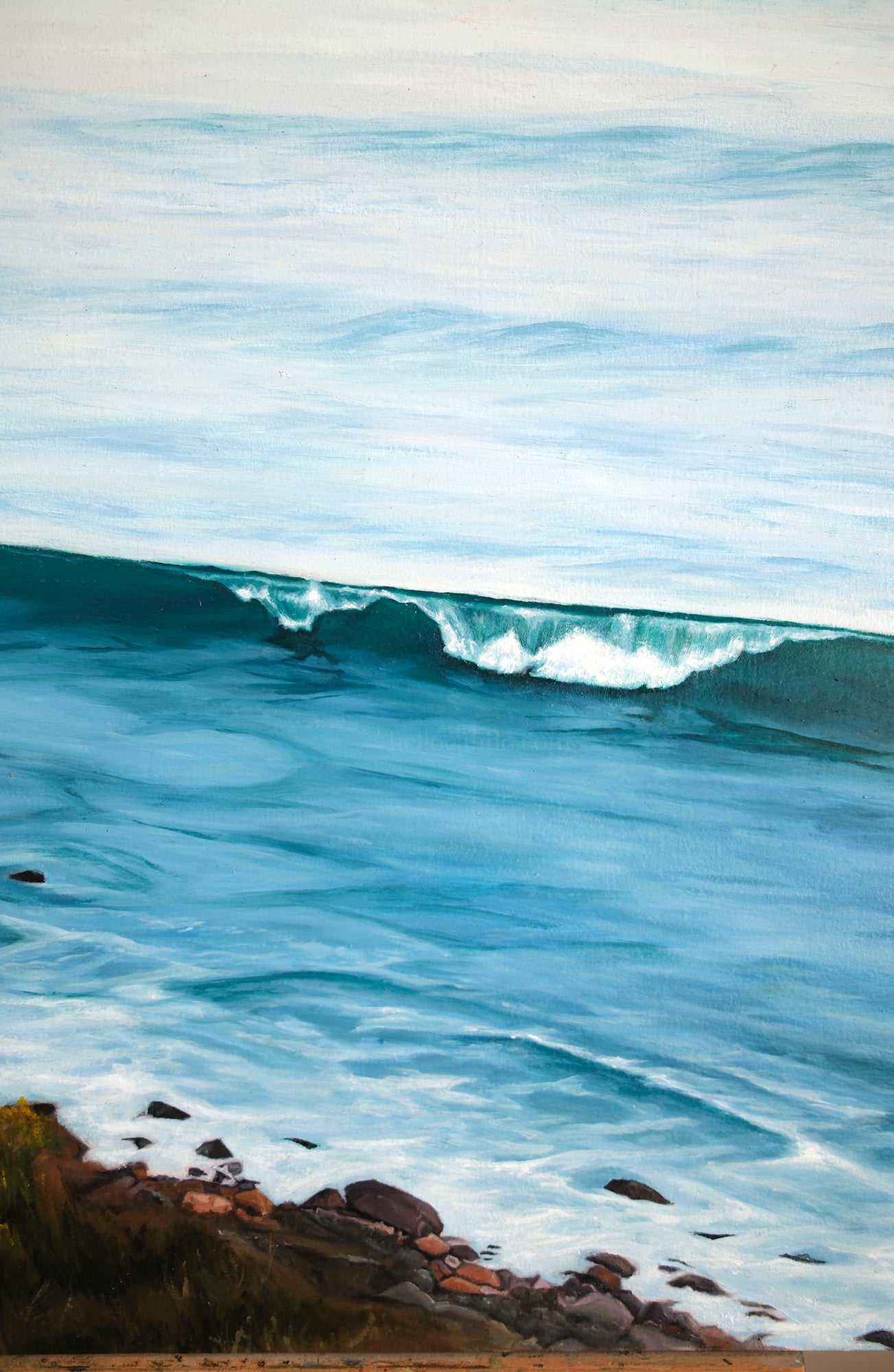Wave crashing onto a rocky shore with a clear sky above