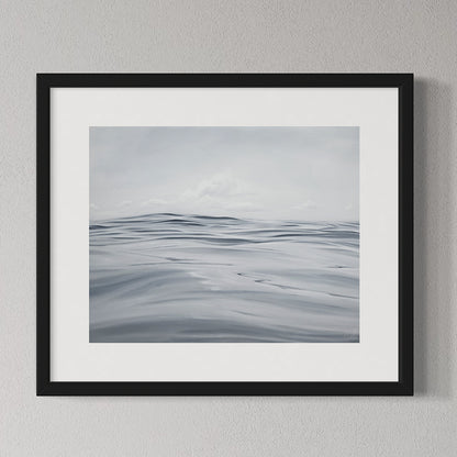 Framed artwork of a gray landscape with wavy lines on a gray wall