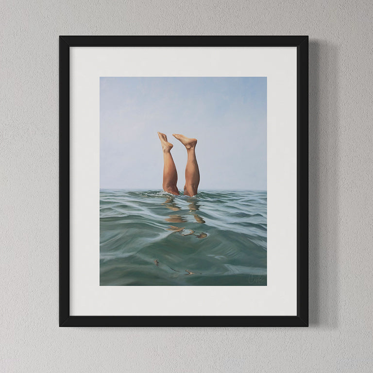 Framed artwork of legs emerging from water with a blue sky background