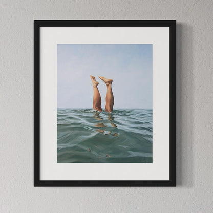 Framed artwork of legs emerging from water with a blue sky background