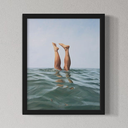 Framed artwork of legs diving into water with a black frame on a light gray wall.