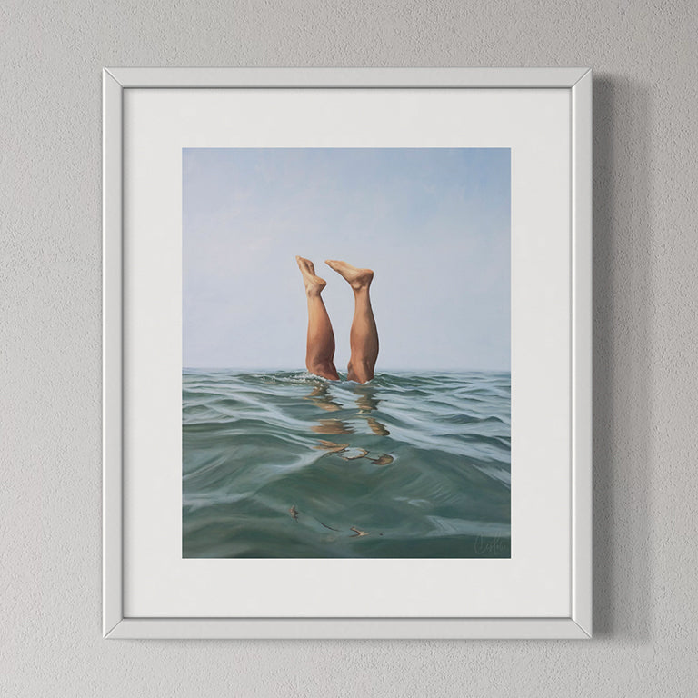 Framed artwork of legs in water with a white frame on a gray wall