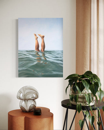Canvas print of legs in water on a wall above a side table with a plant and decorative object.