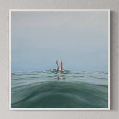 A framed art print titled 'Double Dipped, I', depicting two legs emerging from water, displayed on a wall shelf with decorative objects.
