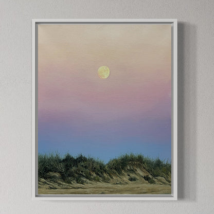 Framed artwork of a sunset over grassy dunes with a full moon.