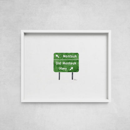 Framed artwork of a green road sign on a gray wall