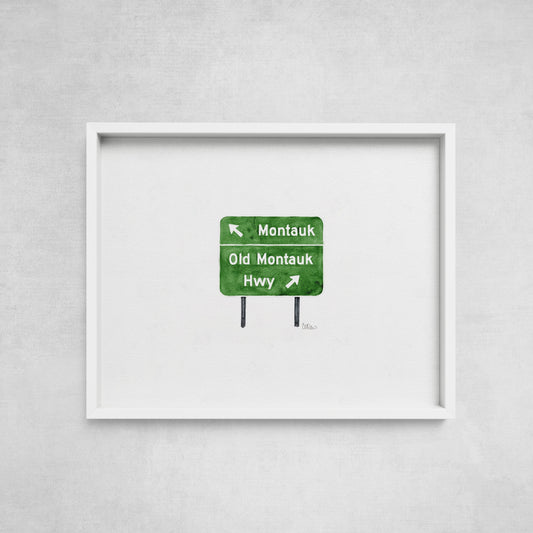 Framed artwork of a green road sign on a gray wall