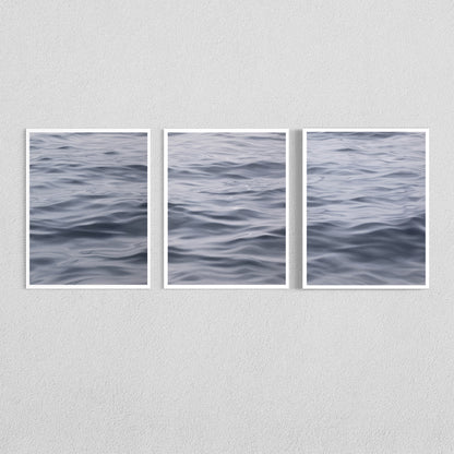 Three framed vertical art prints showing a close-up view of rippling water, arranged side by side on a light gray textured wall.