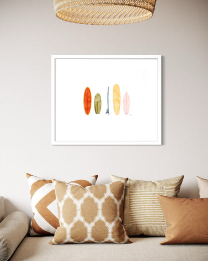 Retro surfboard watercolor print in white frame above coastal boho living room sofa by Candace Ceslow