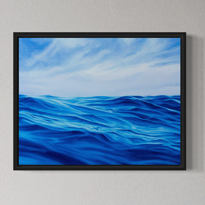Framed artwork of blue ocean waves and sky on a gray wall