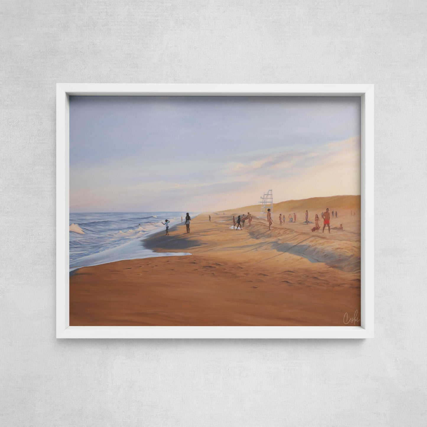 Framed artwork of a beach scene with people on a gray wall.