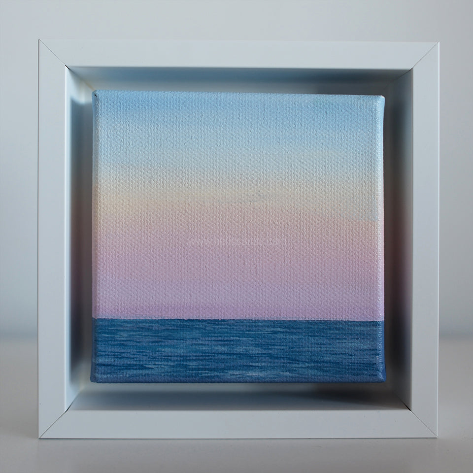 Soft Horizon — Mini #44 pastel coastal oil painting in white frame, blue ocean and pink sky gradient by Montauk artist Candace Ceslow.”