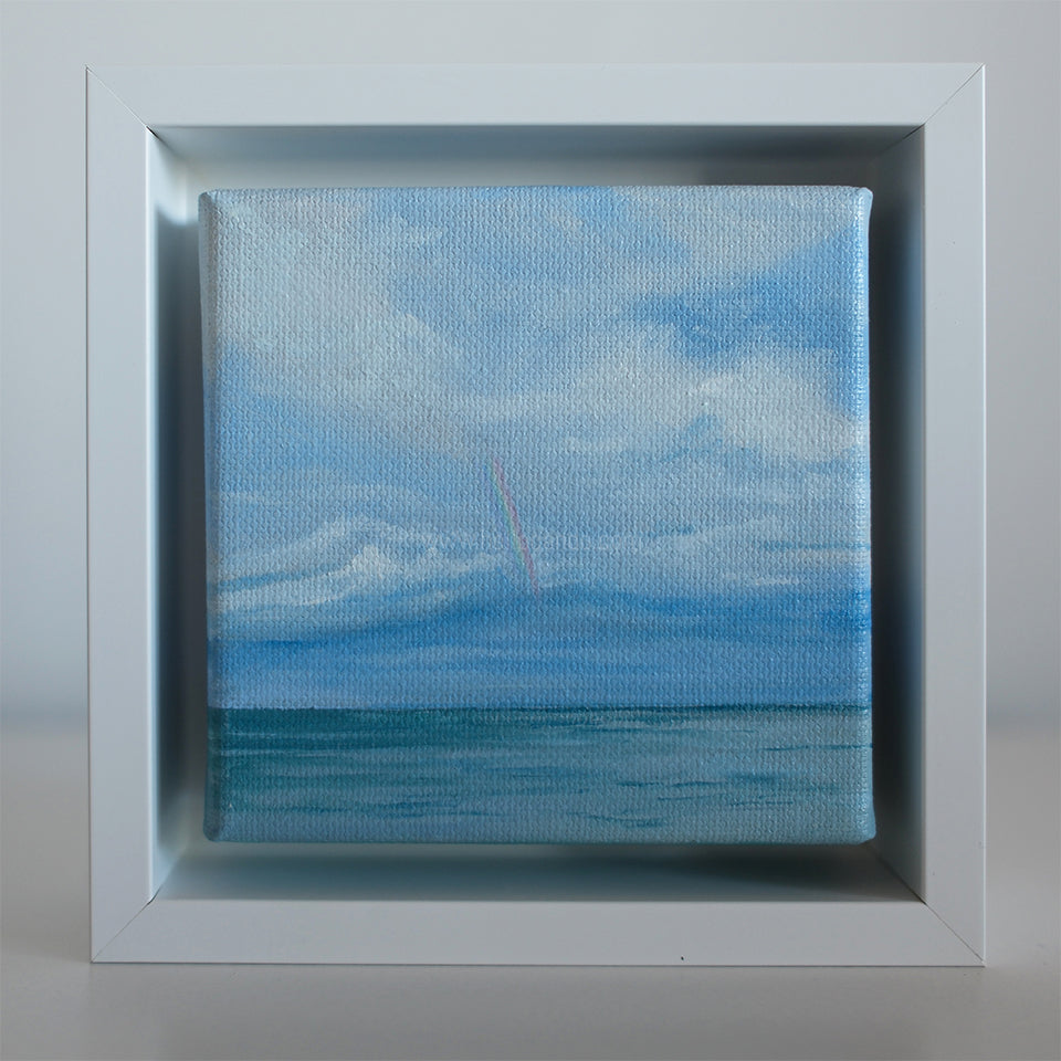 4x4 inch mini oil painting showing a pale rainbow reaching down toward the sea with soft blue clouds above