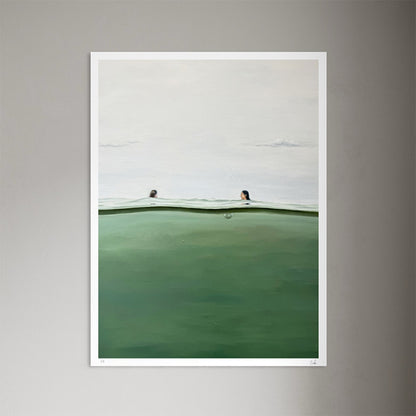A framed art print featuring a minimalist landscape of a green-tinted body of water under a pale gray sky, with two small figures visible above the horizon. The print is displayed against a neutral gray wall.