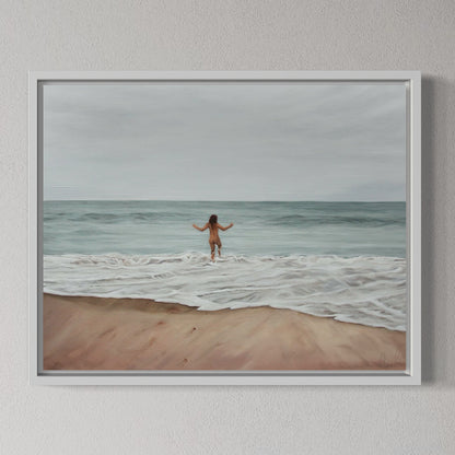 Framed artwork of a person walking on a beach with ocean waves.