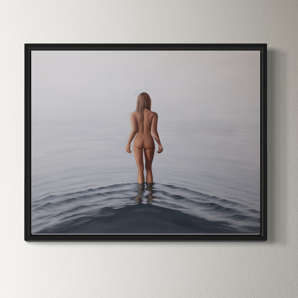Framed artwork of a nude person standing in water on a plain wall.