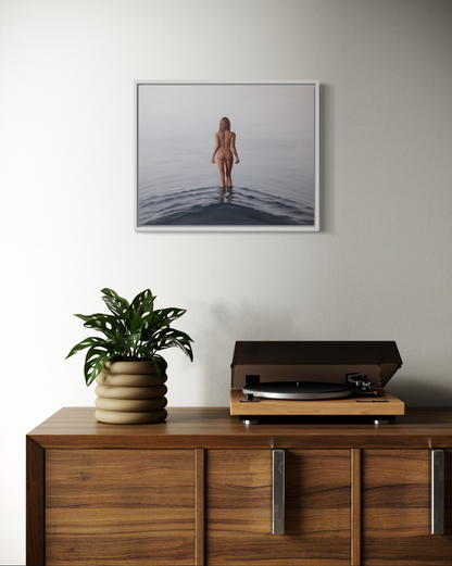 Wooden cabinet with a plant and record player, framed picture on the wall.