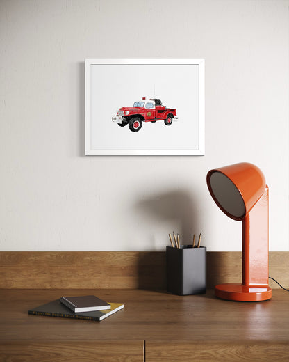 Vintage Montauk fire truck watercolor-style art print in white frame above wood desk by Candace Ceslow