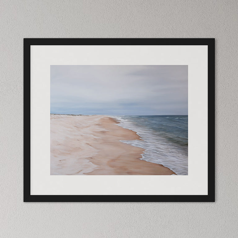 Framed artwork of a beach scene with a black frame on a gray wall.