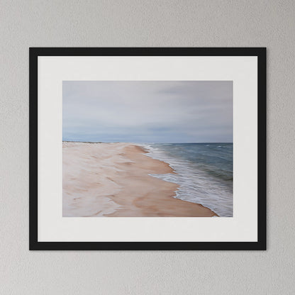 Framed artwork of a beach scene with a black frame on a gray wall.