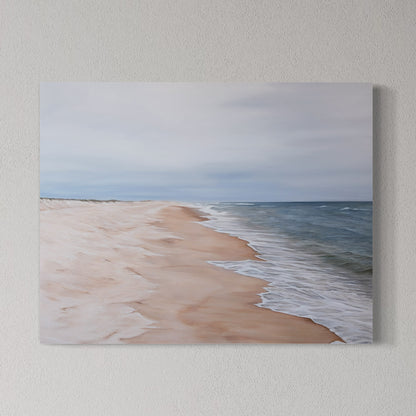 Canvas print of a beach scene with sand and ocean on a wall.