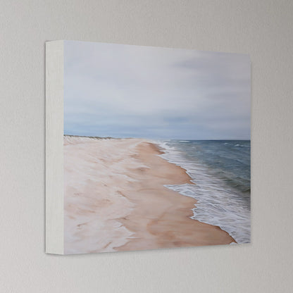 Canvas print of a beach scene with waves and sand on a light gray wall.